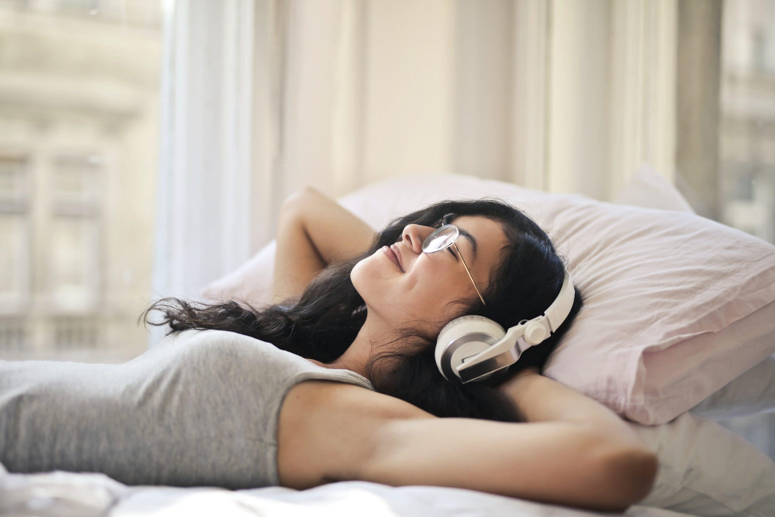 Woman relaxing and listening to music. Courtesy of Pexels.com/Andrea Piacquadio.