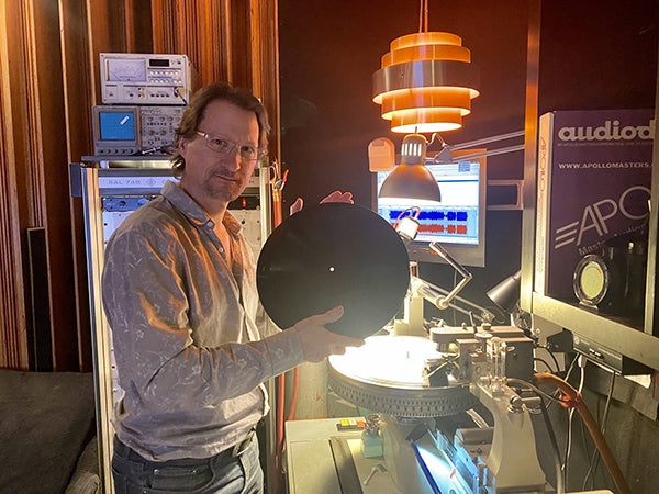 Greg presenting a freshly-cut lacquer master disk, in front of his Neumann VMS-70 disk mastering lathe.