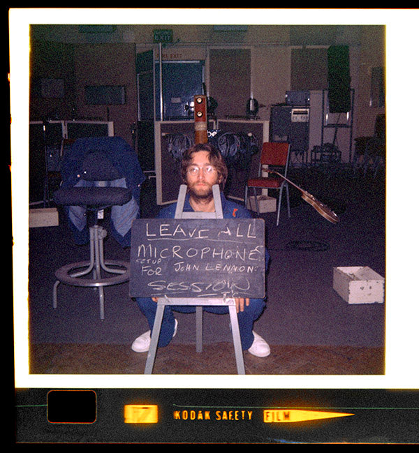 John poses with a chalkboard reminding EMI Studios staff to "leave all microphones set up for John Lennon session," October 10, 1970. Photo: Yoko Ono Lennon © Yoko Ono Lennon.