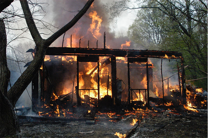 The conflagration after only a few minutes. The fire department had not yet arrived. To the right you can see the framework that held the tarp and the remains of the firewood on fire.