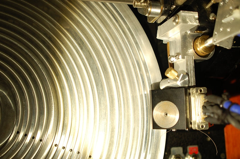 Top view of a heavily modified Fairchild lathe, fitted with a vacuum platter and an advance ball assembly on the FloKaSon Caruso cutter head, along with an oil dashpot on the suspension unit. The assembly right behind the cutter head, with the brass knurled knob off to the side, is the advance ball assembly. The knob is for setting the depth of cut. Courtesy of Agnew Analog Reference Instruments.