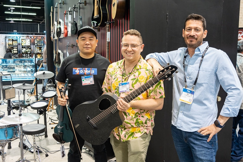 The Donner company shows off several new affordable instruments. utilizing composite materials t. Here Jake Qijie Wu of Donner, holds a violin while Mac Edition Radio’s Thomas Fogel holds their latest carbon fiber guitar and PR person Ari Morguelan keeps the party in check.